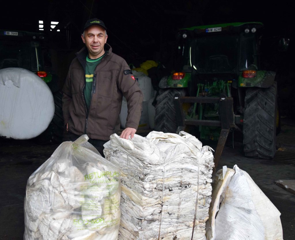 Produktsjef for rundballeplast i Felleskjøpet, Jan Håvard Kingsrød, viser at plast fra 50-60 rundballer blir komprimerer til en 80 kilos firkant med emballasjepressa.